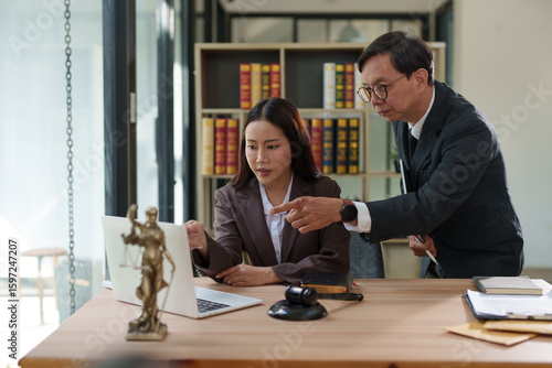 Lawyers are sitting in a meeting, searching for legal documents at the office.	
