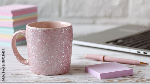 Pink glitter mug and laptop on white wooden desk pink mug