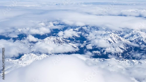 Wallpaper Mural Snowy winter mountain landscape under blue sky with clouds, A high-altitude view of a snow-capped mountain range with clouds swirling around the peaks Creative  cinematic horizontal video footage Torontodigital.ca