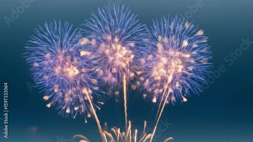 Brilliant blue and gold fireworks explode in a spectacular celebratory display against the dark night sky.