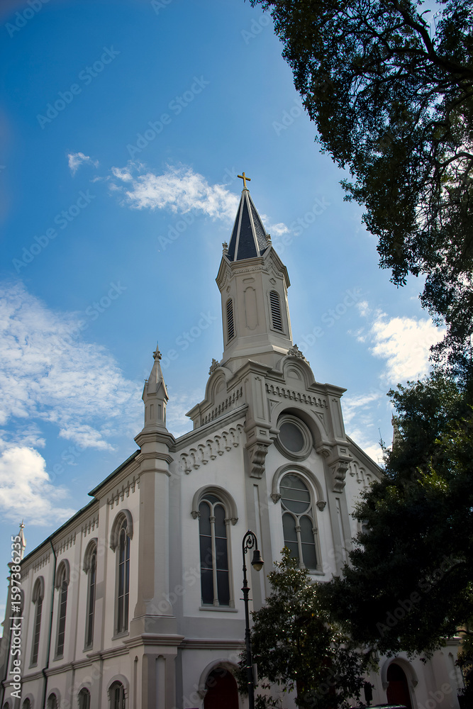 Fototapeta premium Catholic church with a blue sky and clouds in Savannah, Georgia