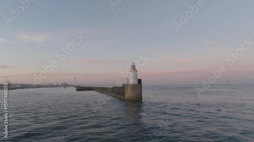 Wallpaper Mural Drone clip at golden hour showing picturesque lighthouse and harbout Torontodigital.ca