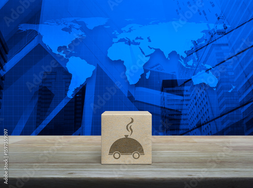 Fototapeta Naklejka Na Ścianę i Meble -  Restaurant cloche icon on wood block cube on wooden table over world map, modern office city tower and skyscraper, Business food delivery online concept, Elements of this image furnished by NASA
