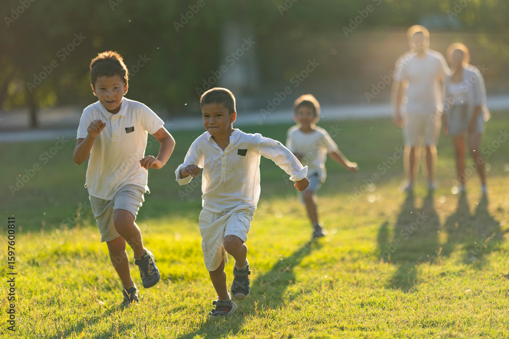 Obraz premium Happy children running on grass in a sunny summer day