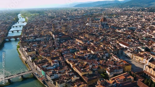 Stunning aerial footage of Florence, Italy, showcasing the Duomo Cathedral, Arno River, and Ponte Vecchio during golden hour with terracotta rooftops, historic landmarks, and Tuscan hills.