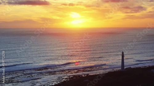 Lighthouse on Coastal Cliff at Ocean Sunset