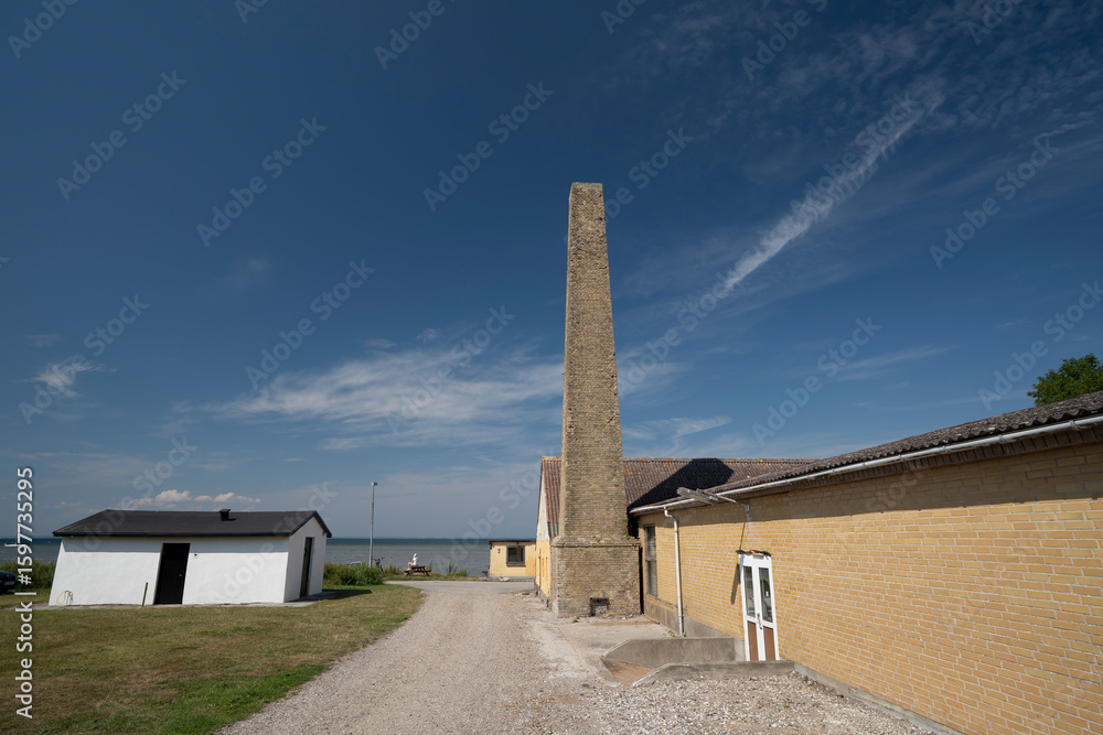 Obraz premium Chimney against blue sky, woman on bench in the background