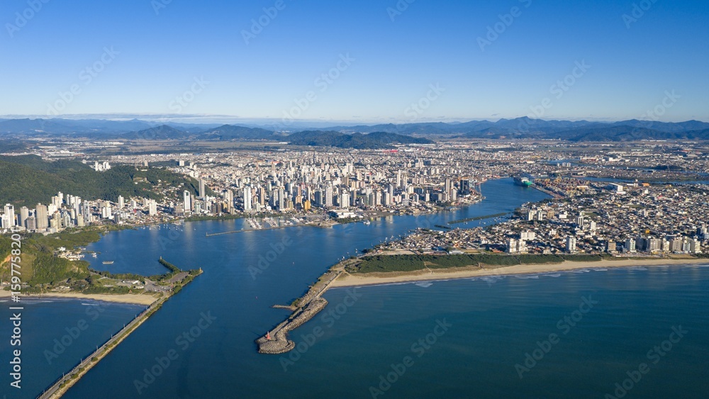 Naklejka premium Aerial view of Itajaí cityscape with the port in the background on a clear sunny day.