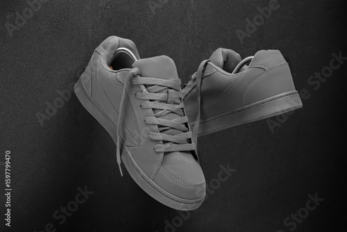 Minimalist grey sneakers on black stone background