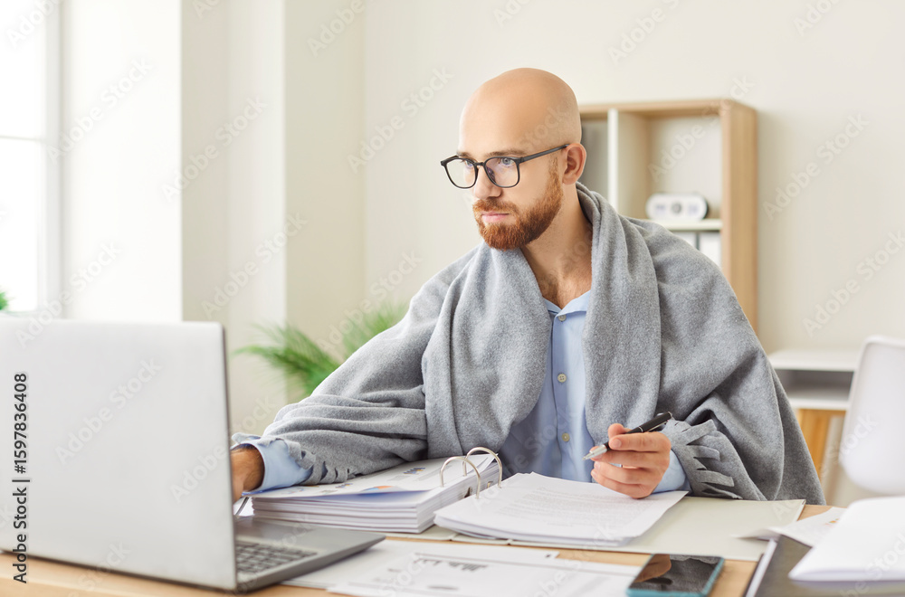 Sick office employee man wrapped in warm blanket working at laptop suffering from cold, fever, flu, influenza, Ill worker feeling bad, unwell, working with health problem, busy accounting at desk Sick office employee man wrapped in warm blanket working at laptop suffering from cold, fever, flu, influenza, Ill worker feeling bad, unwell, working with health problem, busy accounting at desk