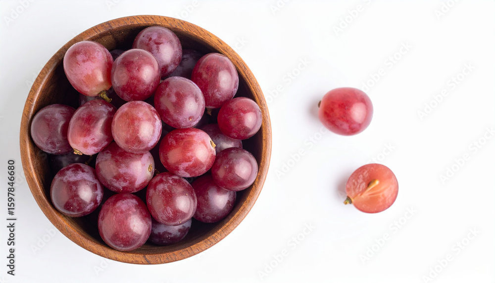 Fototapeta premium a wooden bowl is filled with numerous red purple fruits, occupying the left side of the scene