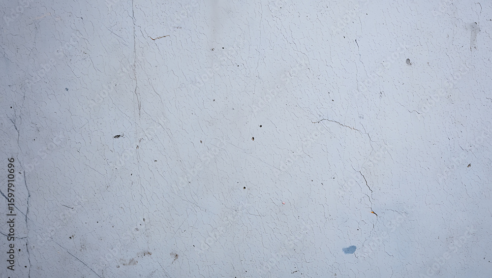 Fototapeta premium Weathered pale blue textured surface with fine cracks and dark speckles cracked