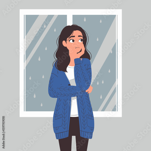 Thoughtful young woman in a cozy blue sweater looking out the window on a rainy day, feeling pensive and melancholic