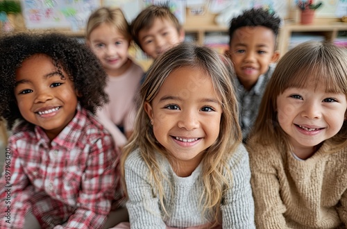 A group of multiethnic children sitting together in the school, smiling and looking at the camera