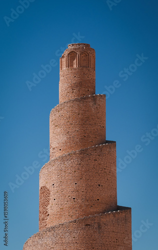 Spiral brick minaret standing tall against clear blue sky in Abu Dulaf Iraq