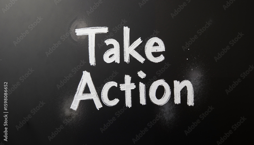 Fototapeta premium Handwriting motivational phrase 'Take Action' on blackboard background 