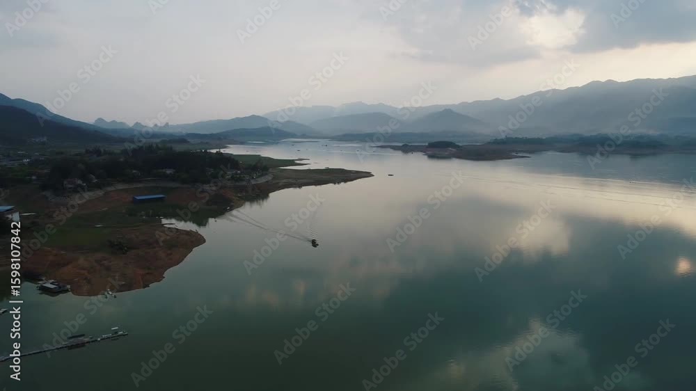 A serene lake reflects the sky and mountains in a chinese landscape A serene lake reflects the sky and mountains in a chinese landscape