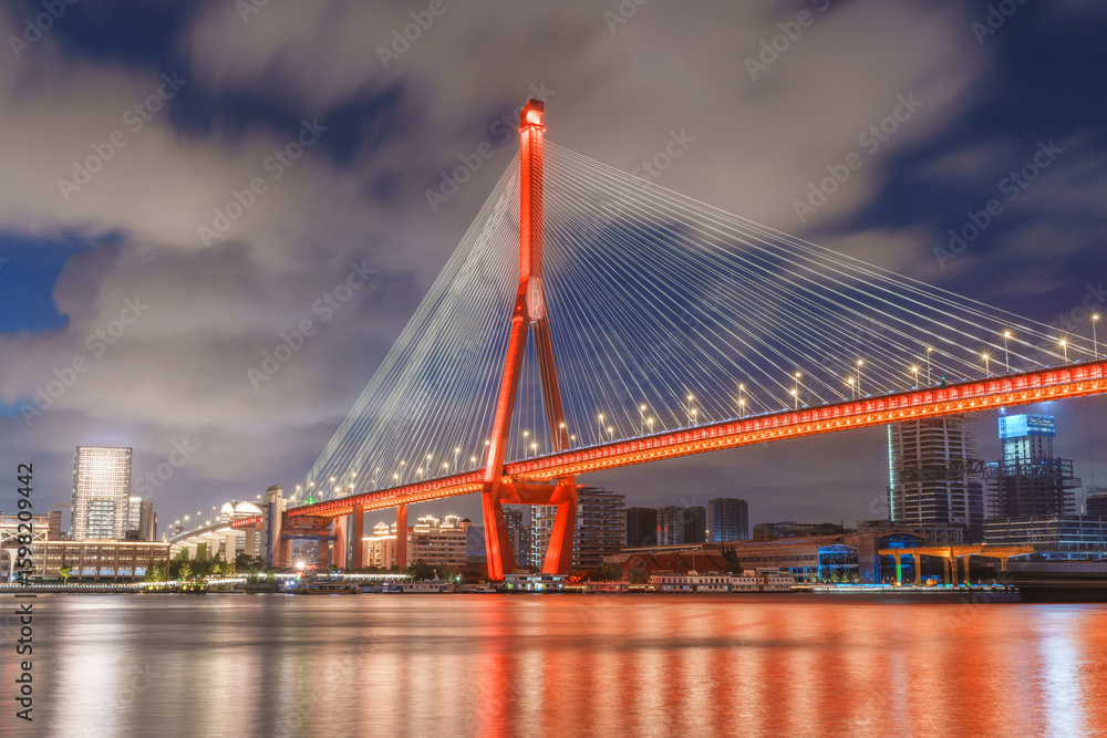 Obraz premium Shanghai Yangpu Bridge glows red in the blue night