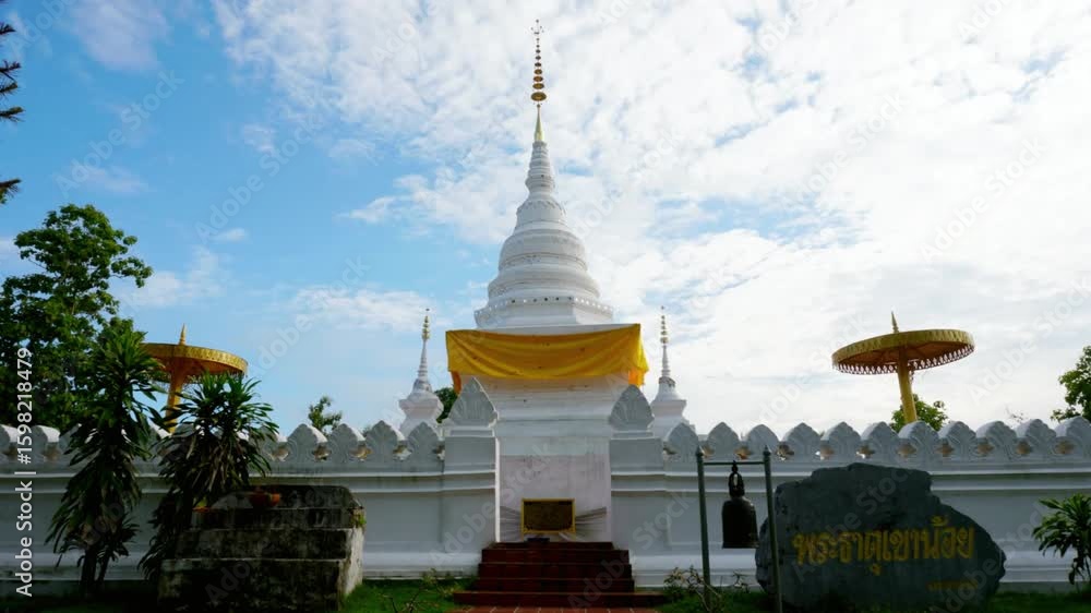 A serene white buddhist temple stands tall under a cloudy sky A serene white buddhist temple stands tall under a cloudy sky
