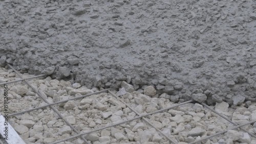 Slow-motion close-up of wet concrete pouring from pipe at construction site. Ideal for infrastructure, process, and industrial themes. Captured at an airport construction project in Turkey