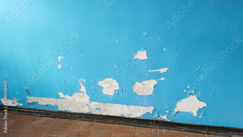 Old home. Cracked blue paint. Dirty floor. Cleaning. Peeling paint background. House repair. Housing service. Plaster. Damaged. terrible condition. Typical Building Wall Defects. Facility inspections.