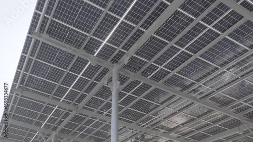 Sunlight beams shining through modern solar panel grid structure. Captured at a renewable energy installation in Turkey. Ideal for sustainability, energy, and technology themes.