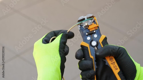 Cropped shot of a man in safety gloves removing insulation with wire stripper
