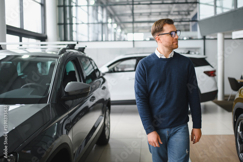 Wallpaper Mural Young man is choosing a new vehicle in car dealership Torontodigital.ca