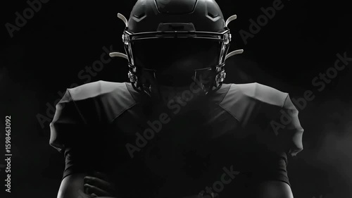 American Football Player in Full Black Gear with Dramatic Low Key Lighting Ready for Intense Action and Professional Sports Performance