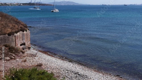Coastal shore with a bunquer of World War II. In the background are shipyards
