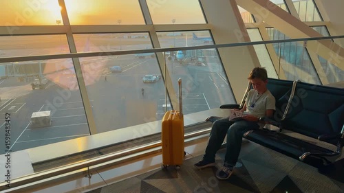 Wallpaper Mural Teen waits at Baku airport while enjoying a book and watching the sunset Torontodigital.ca
