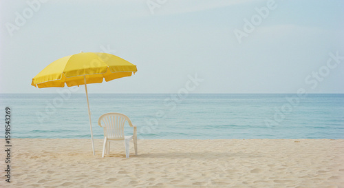 Solitary Beach Chair and Yellow Umbrella: Minimalist Seascape.