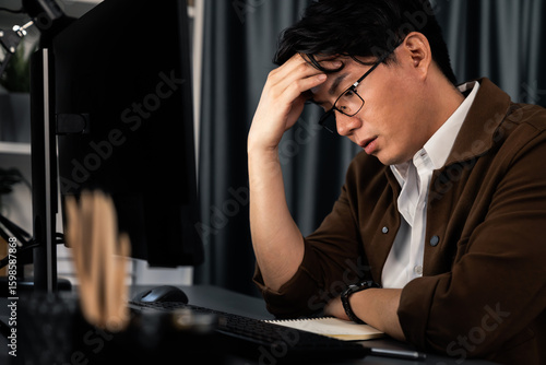 Tapeta Smart businessman with stressful face working on pc to create business plan report over late night time at office, working on searching tool market planning new startup company project job