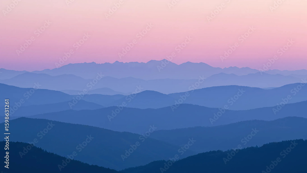 Obraz premium A serene landscape of layered, misty mountains in shades of blue and purple, silhouetted against a soft, gradient sky transitioning from pink at the horizon to a deeper purple above.