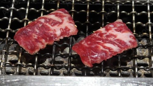Thin beef cuts are hotly grilling on the barbecue.