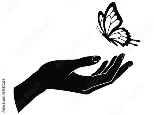 Silhouette of hand releasing a butterfly in flight