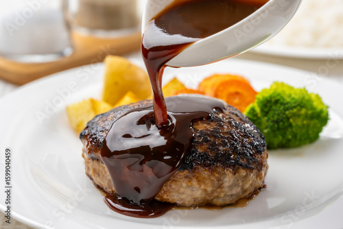 ジューシーなハンバーグにソースをかける