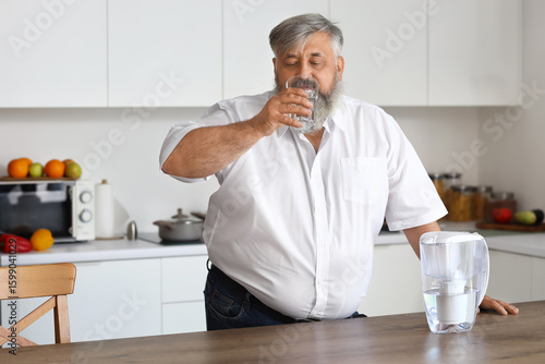 Mature man with filter jug ...