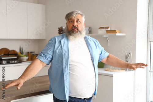 Afraid mature man in kitche...