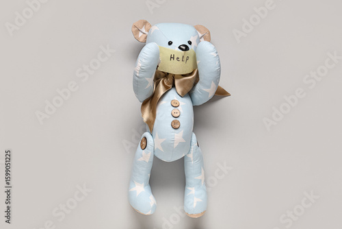 Toy bear with taped mouth a...
