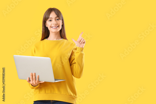 Young woman with laptop poi...