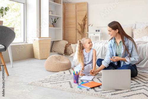 Nanny with cute little girl studying in bedroom