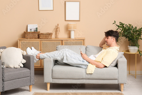 Young man relaxing on sofa ...