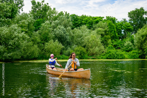 Photography paddling on the toronto islands on a summer day: young adult couple in light bro
