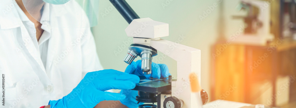 Fototapeta premium Banner Scientist man look Microscope research in science laboratory. Banner Asian scientist use microbiology microscope in laboratory equipment chemistry lab. Biochemistry experiment with copy space