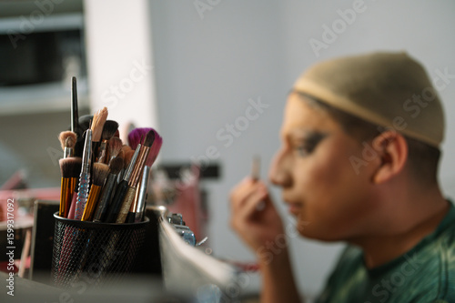 A drag queen putting on her makeup before going out to perform at a local theater in Peru.