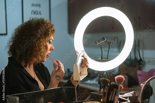 A drag queen putting on her makeup before going out to perform at a local theater in Peru.
