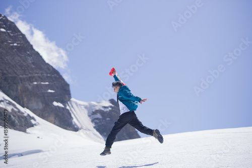 Man celebrating with Peruvian flag on snowy Andes mountain
