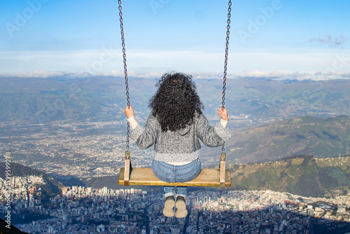 Young woman on a swing in the mountains