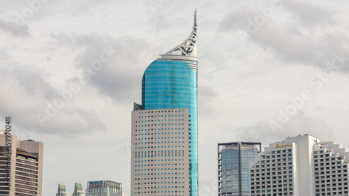 view of a public park with a lake in Jakarta in the morning with a background of modern buildings on the lake side